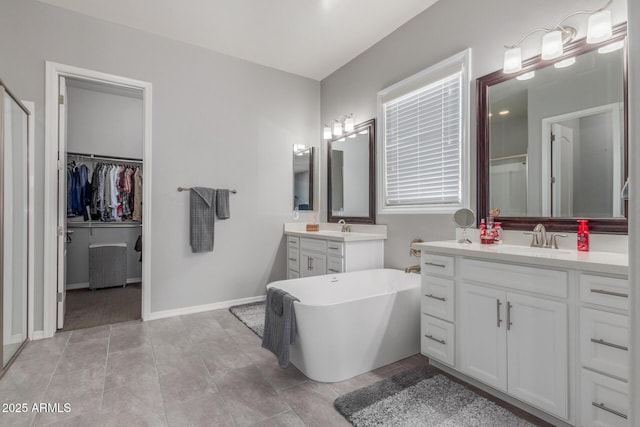 1342 E Milada Dr, Phoenix, AZ 85042 - bathroom with two vanities, a freestanding bath, a shower stall, tile patterned floors, and baseboards