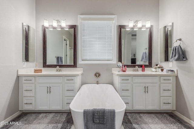 1342 E Milada Dr, Phoenix, AZ 85042 - full bathroom featuring two vanities, a freestanding tub, and baseboards