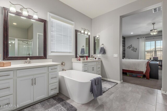1342 E Milada Dr, Phoenix, AZ 85042 - ensuite bathroom with two vanities, a shower stall, a freestanding tub, a ceiling fan, and baseboards