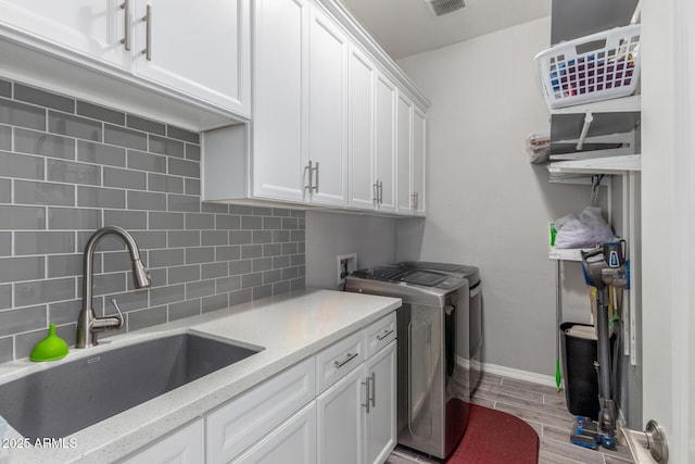 1342 E Milada Dr, Phoenix, AZ 85042 - washroom featuring washing machine and clothes dryer, cabinet space, light wood-type flooring, and baseboards