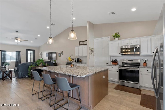 kitchen featuring white cabinetry, visible vents, appliances with stainless steel finishes, and a center island