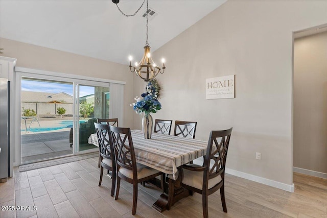 dining area with visible vents, baseboards, light wood-style flooring, and vaulted ceiling