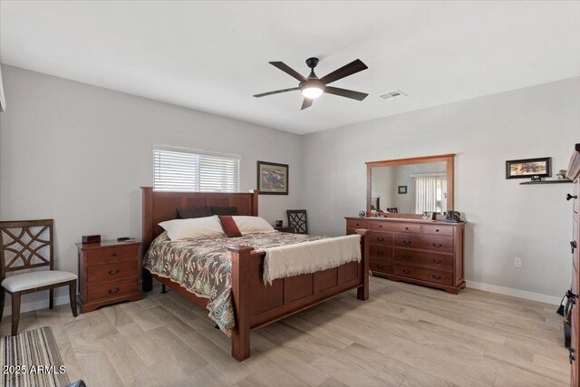 bedroom featuring visible vents, baseboards, light wood-style flooring, and a ceiling fan