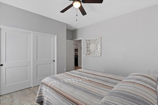 bedroom featuring a closet, washer / dryer, and a ceiling fan