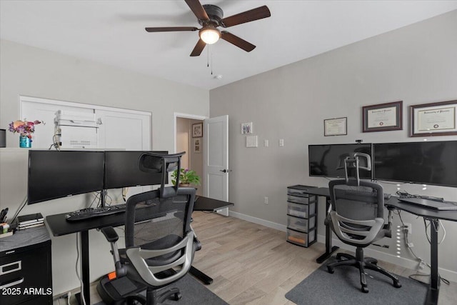 home office featuring a ceiling fan, light wood-type flooring, and baseboards