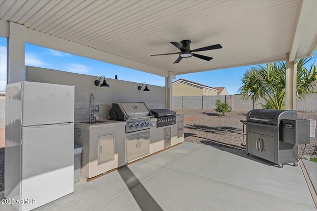 view of patio / terrace featuring a sink, fence, and grilling area