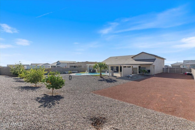 rear view of house with a patio area, a fenced in pool, and a fenced backyard