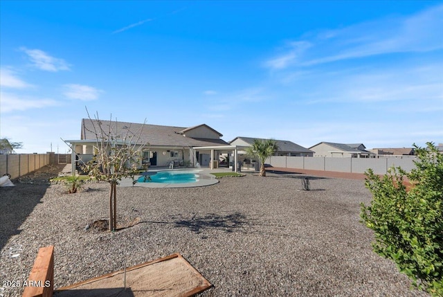 back of property featuring a fenced in pool, a fenced backyard, and a patio area