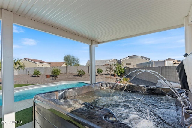 view of swimming pool with a jacuzzi and a fenced backyard