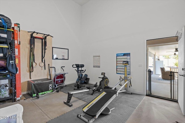 exercise room with a high ceiling and baseboards