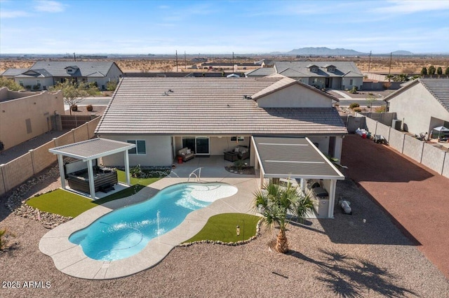 rear view of property featuring a residential view, a patio, a fenced backyard, and a tiled roof