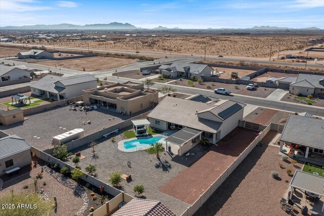 aerial view featuring view of desert, a mountain view, and a residential view