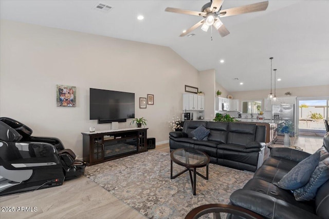 living room featuring visible vents, baseboards, ceiling fan, wood finished floors, and high vaulted ceiling