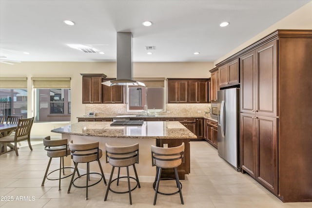 644 E Las Puertas Ln, Queen Creek, AZ 85140 - kitchen with visible vents, stainless steel refrigerator with ice dispenser, a sink, a breakfast bar, and island range hood