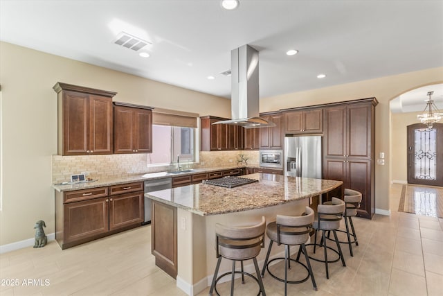 644 E Las Puertas Ln, Queen Creek, AZ 85140 - kitchen featuring arched walkways, visible vents, a kitchen island, a sink, and stainless steel appliances