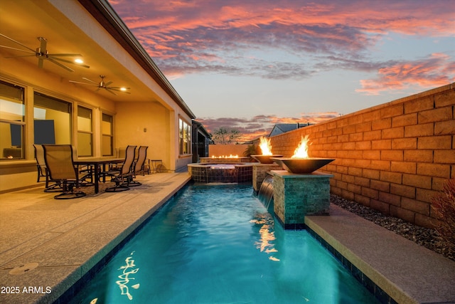 644 E Las Puertas Ln, Queen Creek, AZ 85140 - pool at dusk featuring a patio, a fire pit, a pool with connected hot tub, and ceiling fan