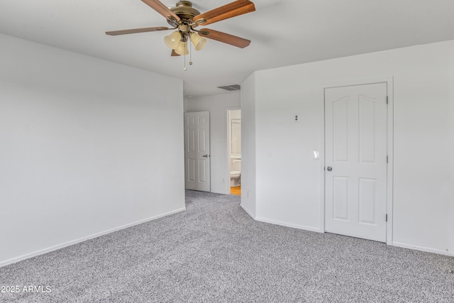 carpeted spare room featuring visible vents, baseboards, and a ceiling fan