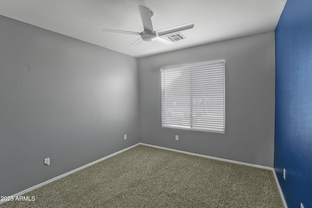 empty room with visible vents, carpet flooring, baseboards, and ceiling fan