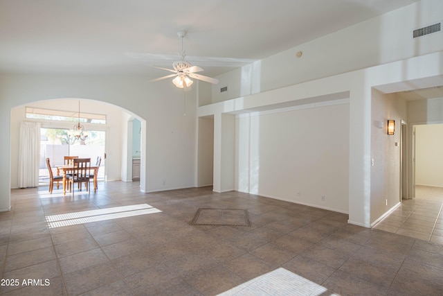 unfurnished living room featuring lofted ceiling, tile patterned flooring, and ceiling fan with notable chandelier