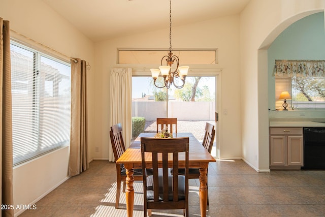 dining area featuring plenty of natural light, a chandelier, vaulted ceiling, and dark tile patterned flooring