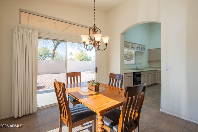 dining room featuring an inviting chandelier, sink, and dark tile patterned floors