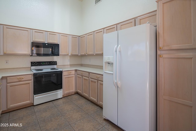 kitchen with light brown cabinetry, light tile patterned floors, white fridge with ice dispenser, electric stove, and a high ceiling