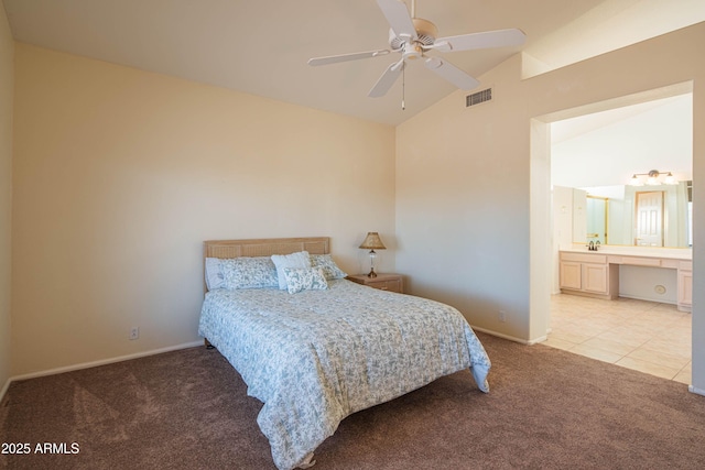 bedroom with ceiling fan, lofted ceiling, connected bathroom, and light carpet