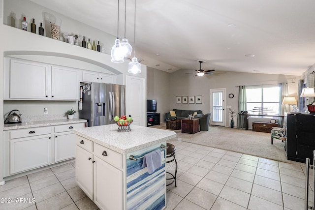 kitchen with white cabinetry, light carpet, stainless steel refrigerator with ice dispenser, decorative light fixtures, and lofted ceiling