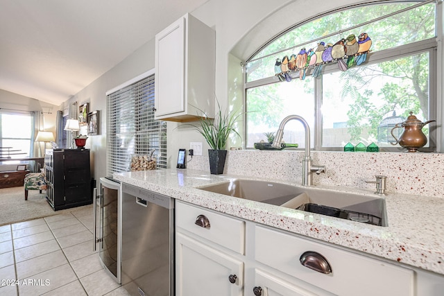 kitchen featuring dishwasher, a wealth of natural light, white cabinetry, and light stone counters