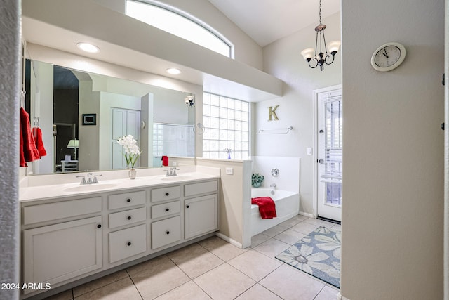 bathroom featuring a wealth of natural light, vanity, a tub to relax in, and tile patterned floors