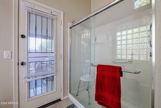 bathroom featuring an enclosed shower, a wealth of natural light, and tile patterned floors