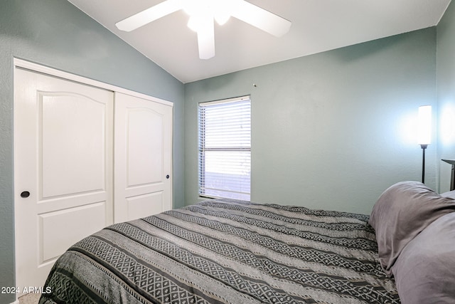 bedroom with ceiling fan, a closet, and lofted ceiling