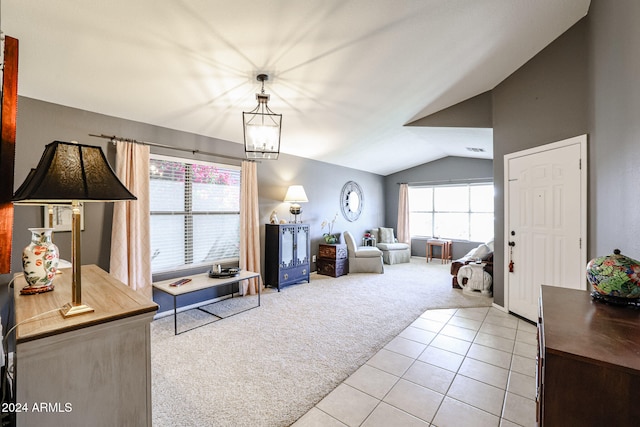 living room with light colored carpet, a chandelier, and vaulted ceiling