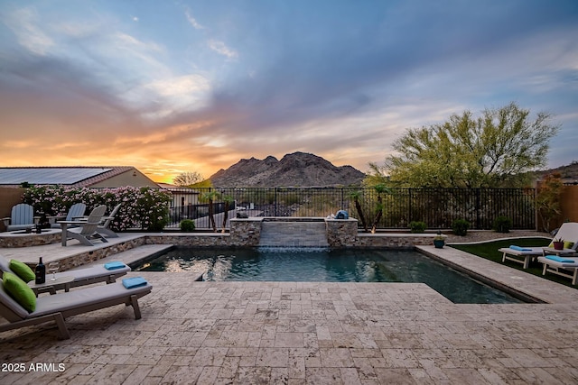 27276 N 81st Ln, Peoria, AZ 85383 - pool at dusk with an outdoor fire pit, a fenced backyard, a patio area, and a mountain view