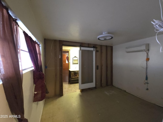 interior space featuring a barn door and a wall unit AC