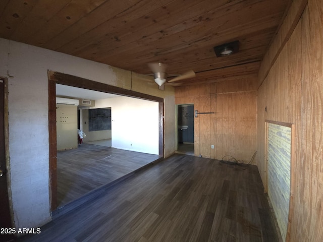 empty room with dark hardwood / wood-style flooring, a wall mounted AC, ceiling fan, wooden ceiling, and wood walls