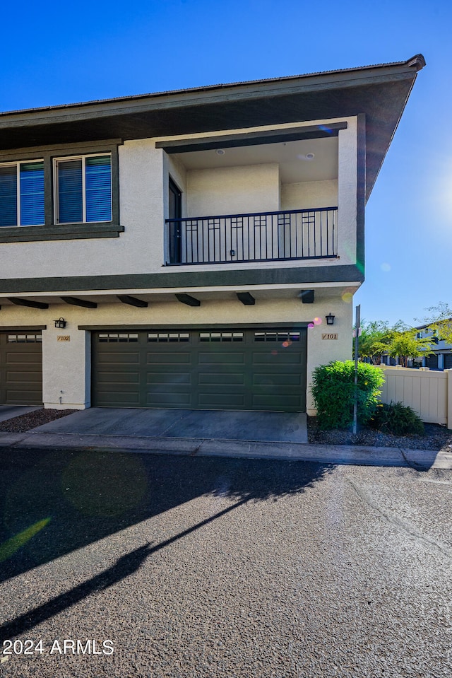 view of front of house featuring a garage and a balcony