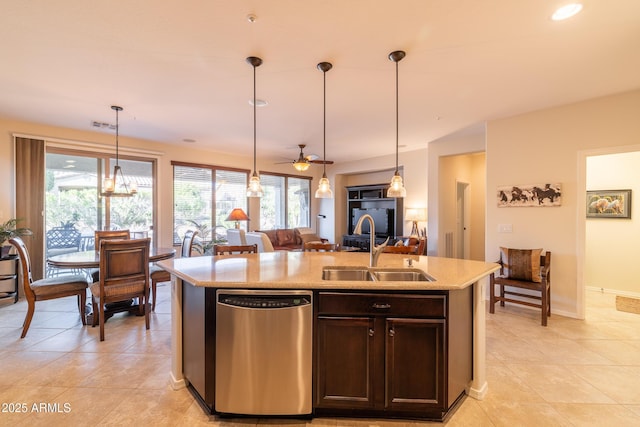 kitchen featuring dishwasher, decorative light fixtures, an island with sink, and a sink