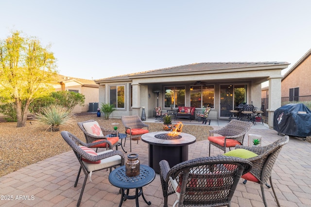 view of patio with central AC unit, a fire pit, a grill, and a ceiling fan