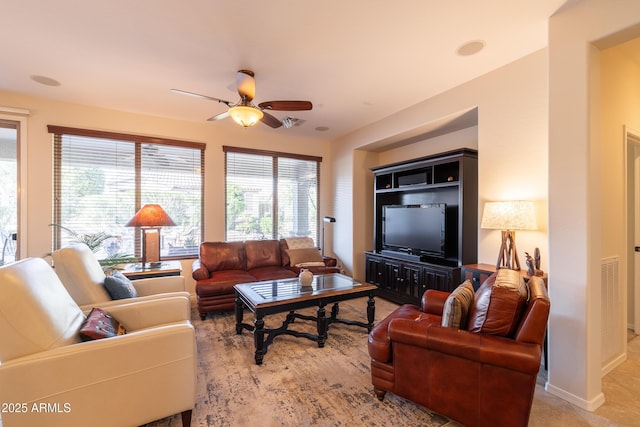 living room with a healthy amount of sunlight, baseboards, and ceiling fan