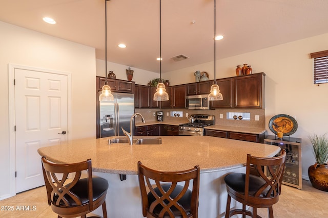 kitchen with dark brown cabinetry, appliances with stainless steel finishes, tasteful backsplash, and a sink