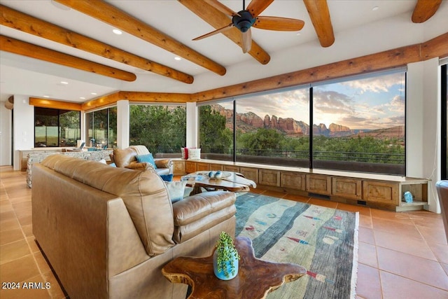 sunroom / solarium featuring ceiling fan and beam ceiling