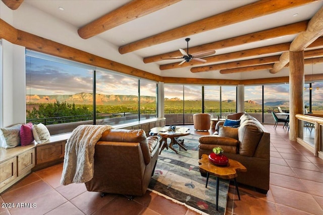 sunroom / solarium with beamed ceiling, a mountain view, and ceiling fan