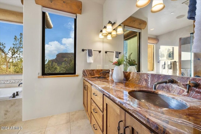 bathroom with vanity, tiled bath, and tile patterned flooring