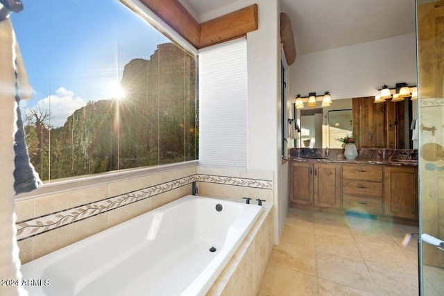 bathroom with a relaxing tiled tub, tile patterned floors, and vanity