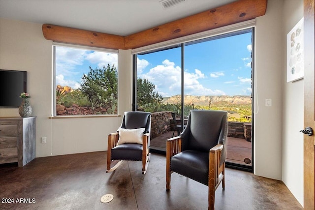 sitting room featuring concrete flooring and a mountain view