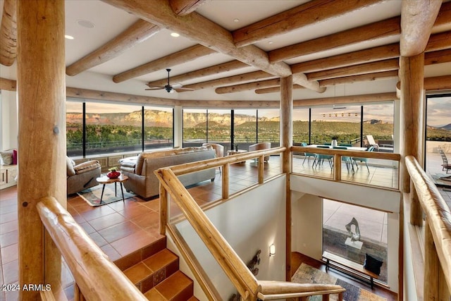 sunroom / solarium featuring beam ceiling and ceiling fan