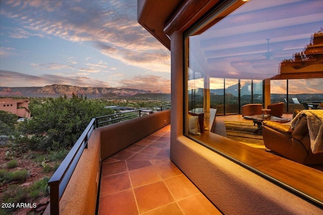 balcony at dusk featuring a mountain view