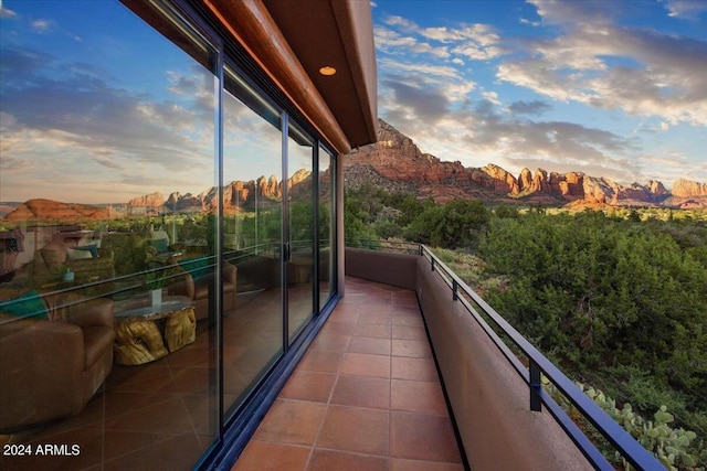 balcony at dusk featuring a mountain view