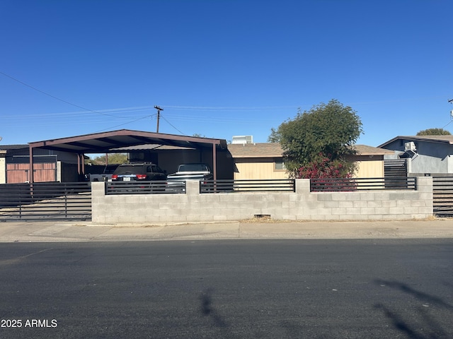 view of front of home featuring driveway and fence